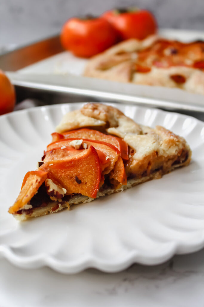 angled shot of a slice of persimmon galette on a plate