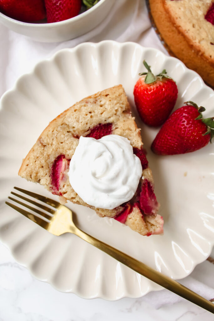 overview shot of a slice of vegan strawberry cake with coconut yogurt on top