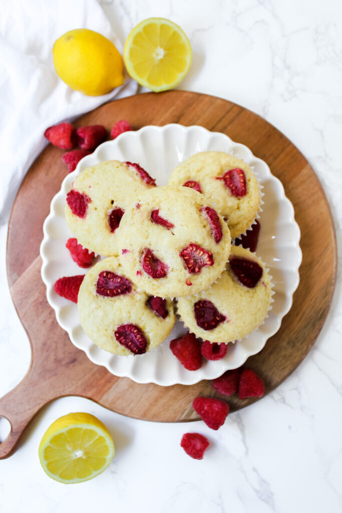 overview shot of vegan raspberry lemon muffins ona plate on top of a wooden board