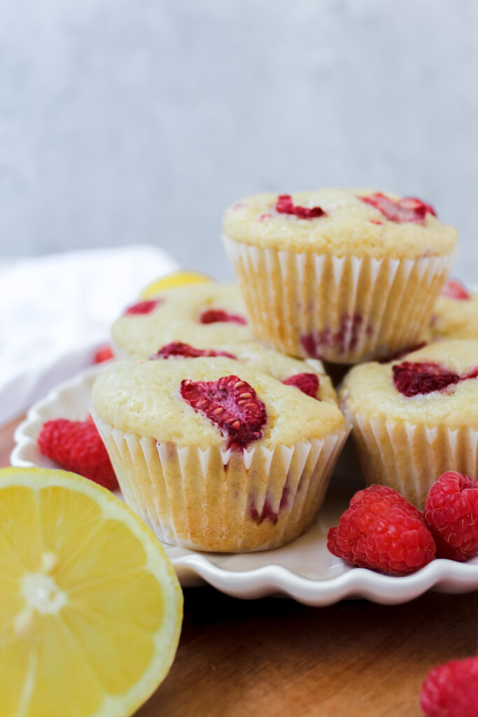 side angle shot of raspberry lemon muffins on a plate