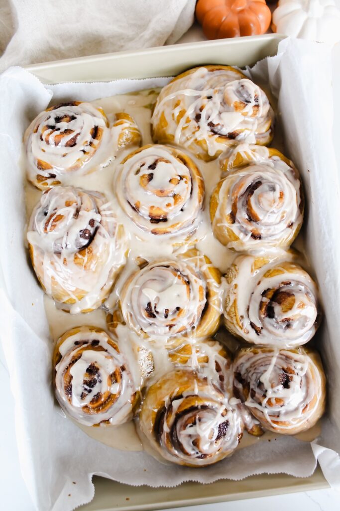 overview shot of vegan pumpkin cinnamon rolls with maple glaze