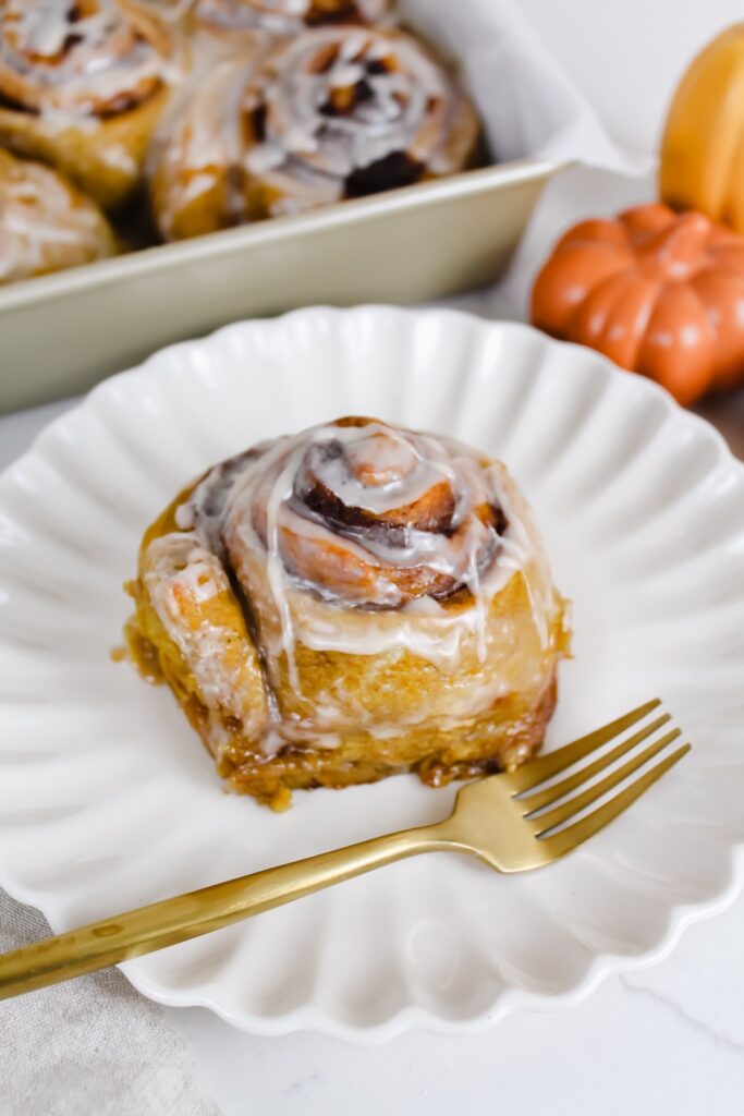 pumpkin cinnamon roll on a white plate