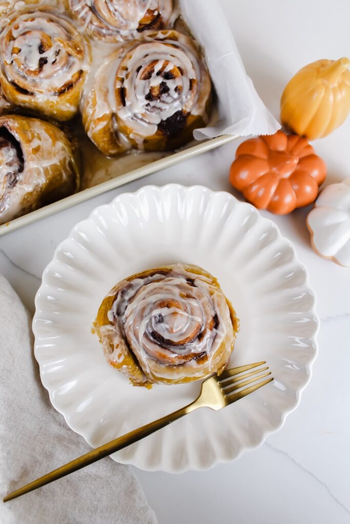 overview shot of vegan pumpkin cinnamon roll on a white plate
