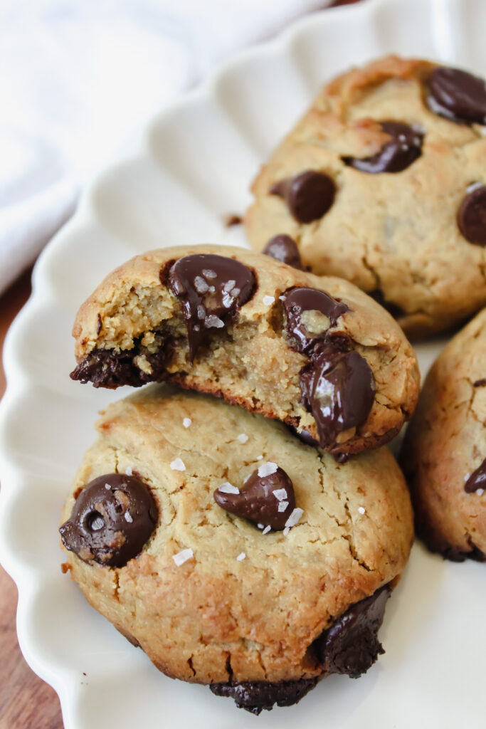 close up bite shot of a chocolate chip cookie laying on top of another cookie