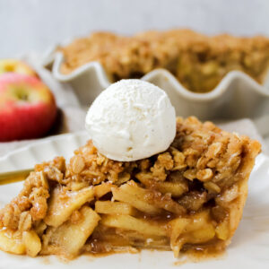 side view shot of a slice of apple pie with ice cream on top