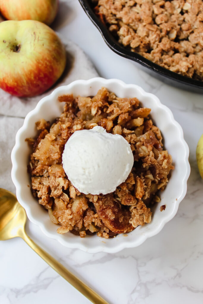 overview shot of a bowl of apple crisp with ice cream