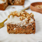 angled shot of a slice of the best healthy carrot cake on a plate