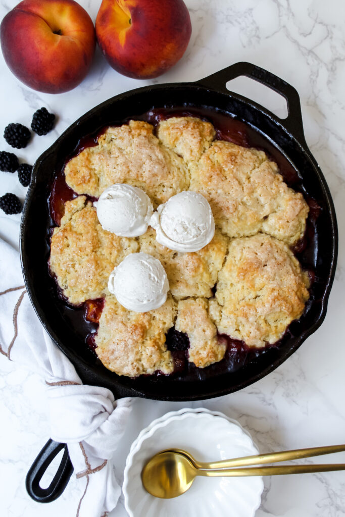 overview shot of vegan blackberry peach cobbler with ice cream on top