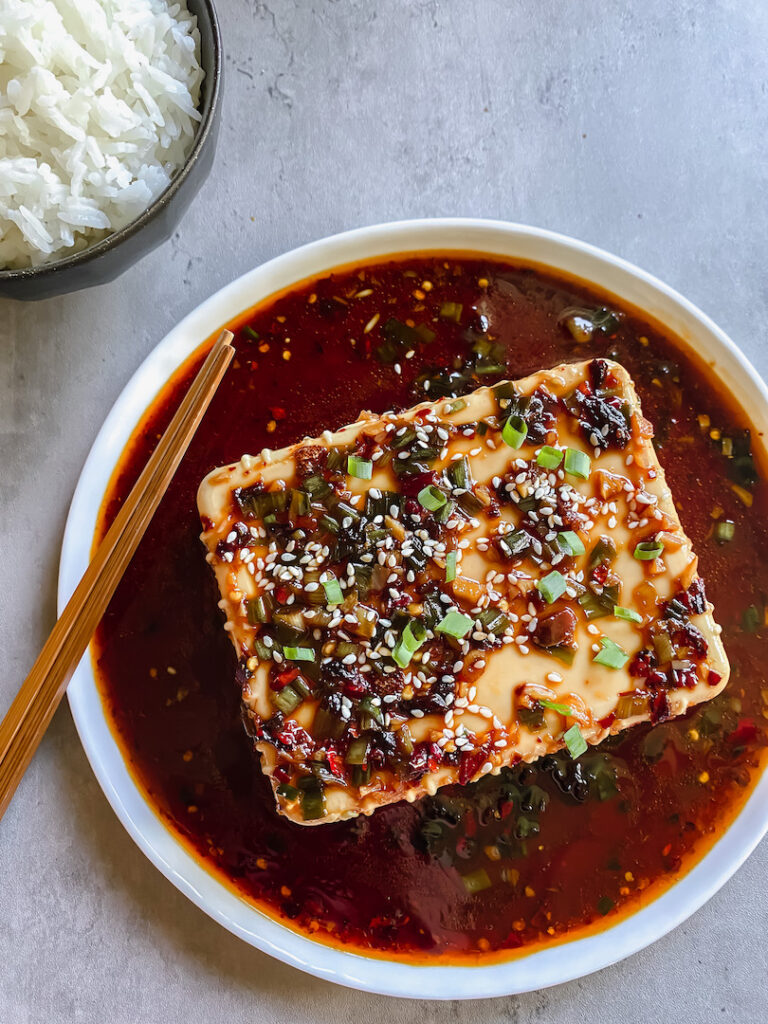 close up picture of silken tofu with garlic onion soy sauce