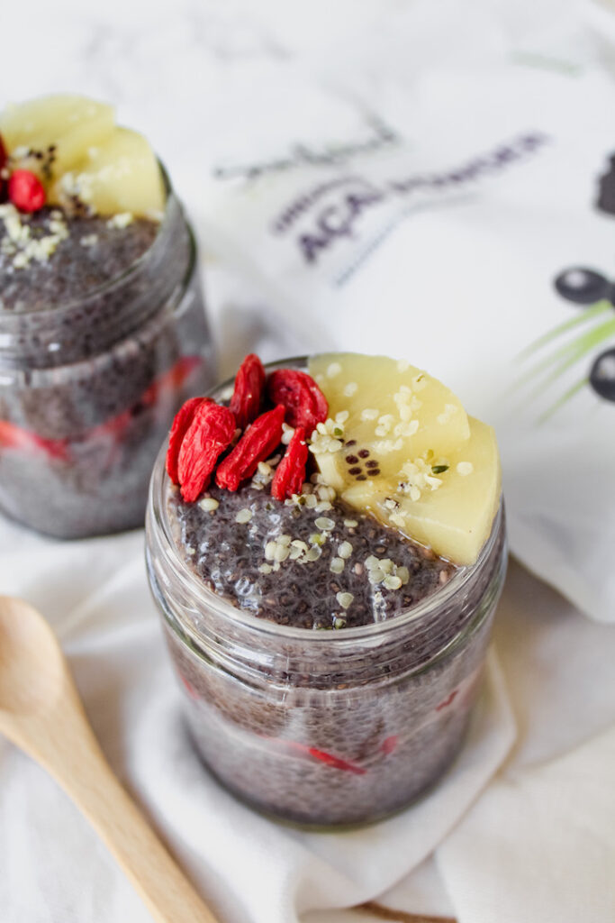 picture of acai chia seed pudding in a jar with acai powder package in the background