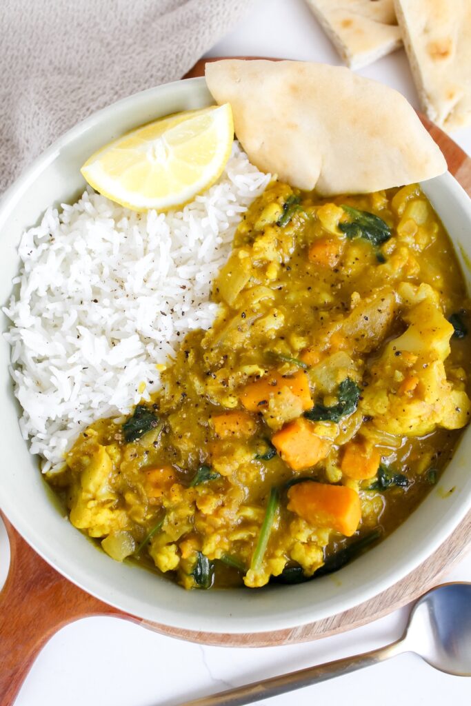 overview shot of bowl with curry, rice, and naan
