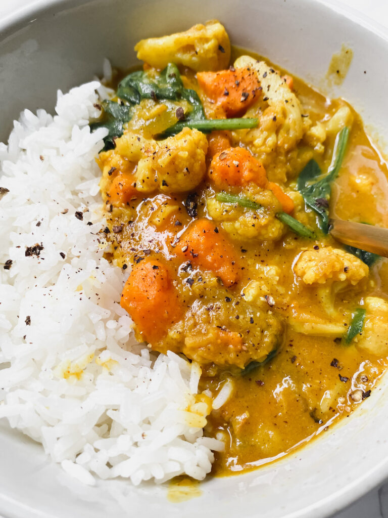 angled close up of cauliflower sweet potato lentil curry and rice 