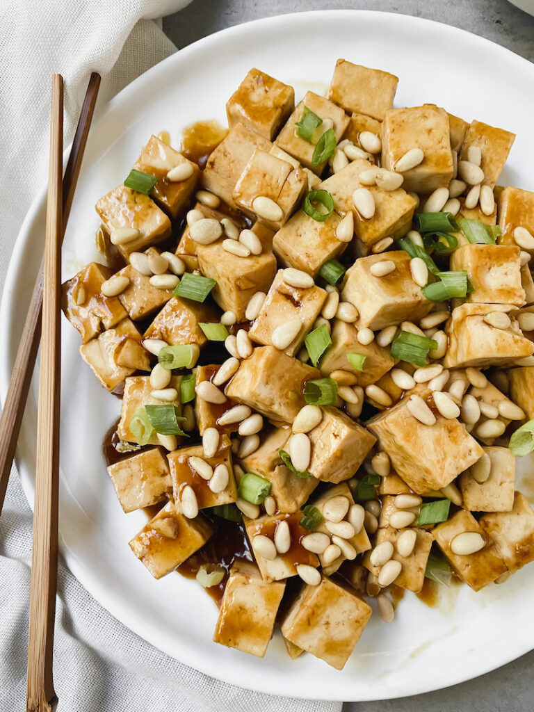 close up shot of tofu and chopsticks on the side