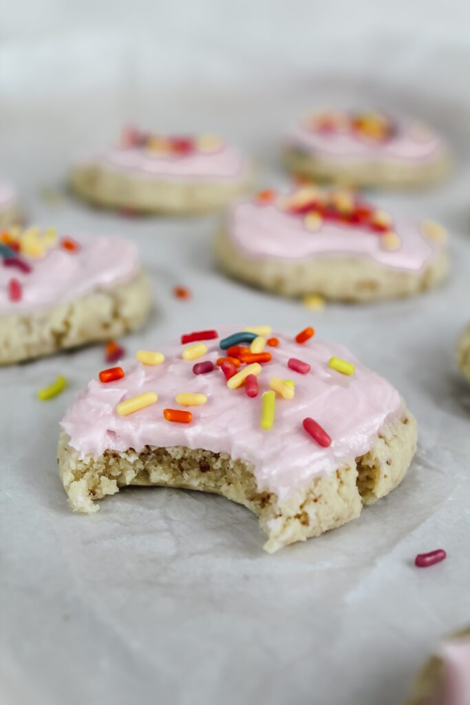 angled shot of a bite taken out of a soft baked sugar cookie