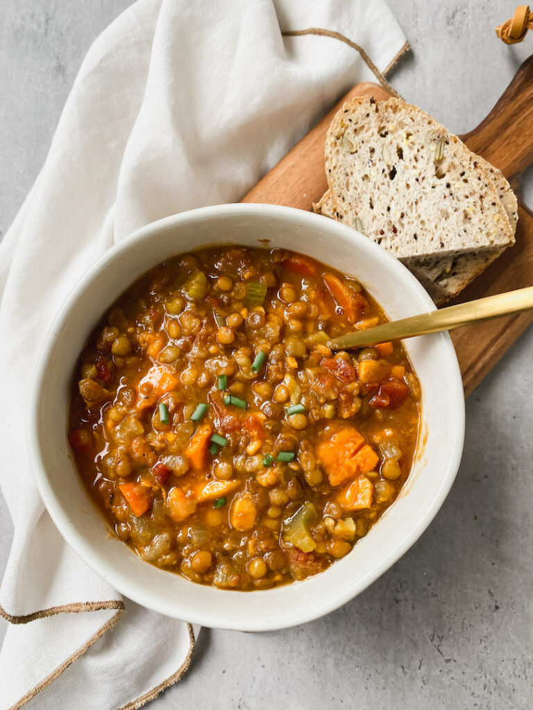 overview shot of a bowl of lentil soup and bread