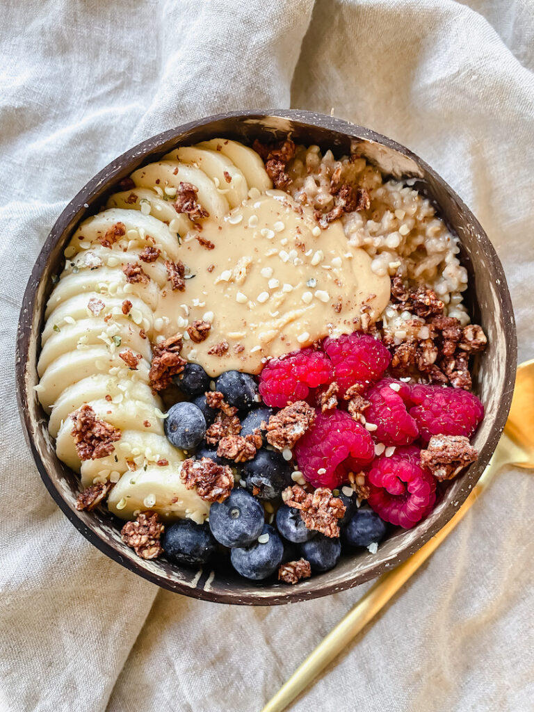 overview shot of bowl of easy instant pot steel cut oats with toppings and a spoon on the side