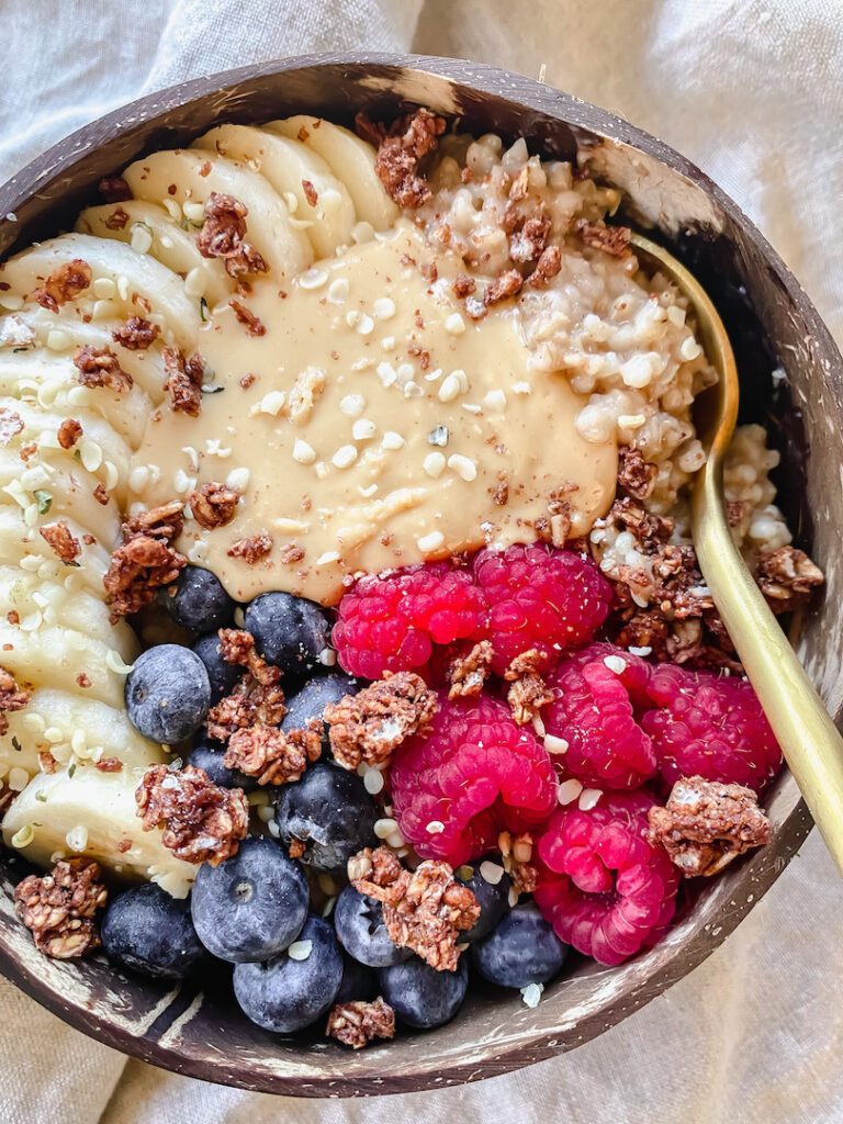close up of oats with fruit, nut butter, and a spoon in it