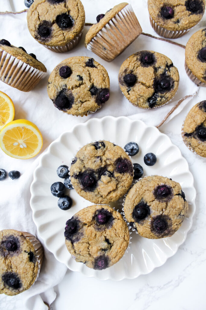 Overview shot of healthy lemon blueberry muffins on a plate and some on the counter