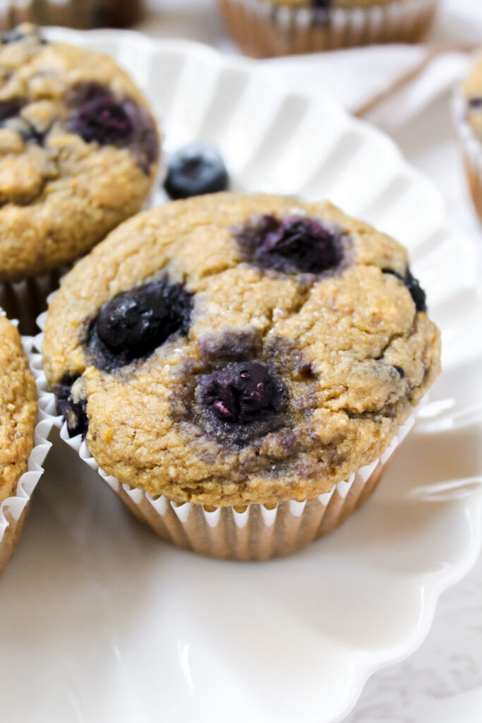 close up angle shot of one healthy lemon blueberry muffin on a plate
