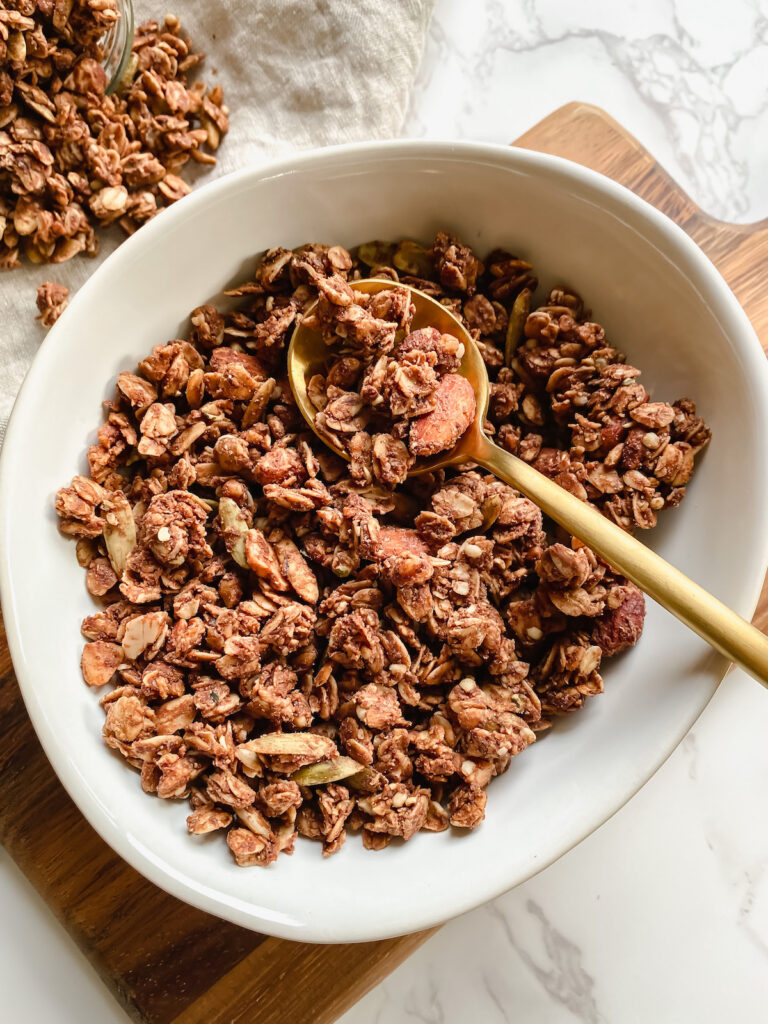 bowl of peanut butter cacao granola with a spoon