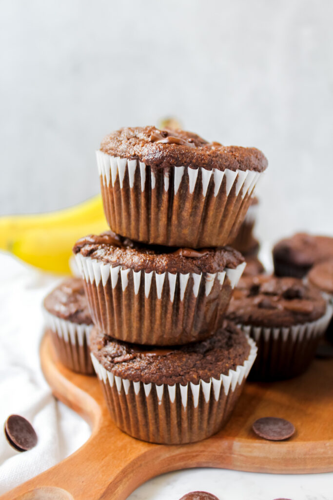 healthy chocolate banana muffins stacked on top of each other