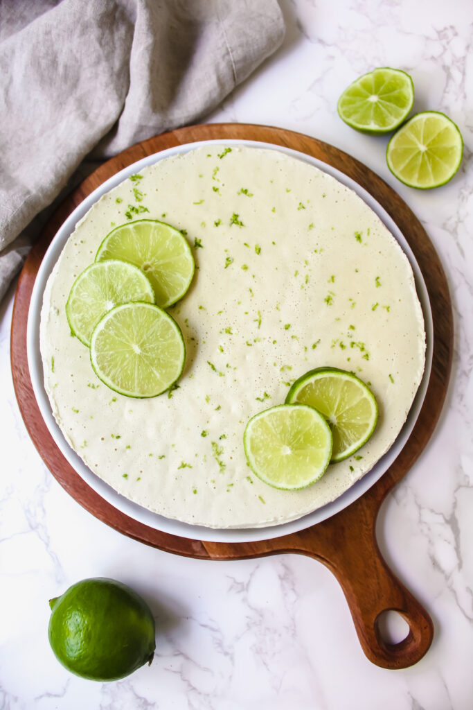overview shot of entire vegan key lime pie on a wooden board