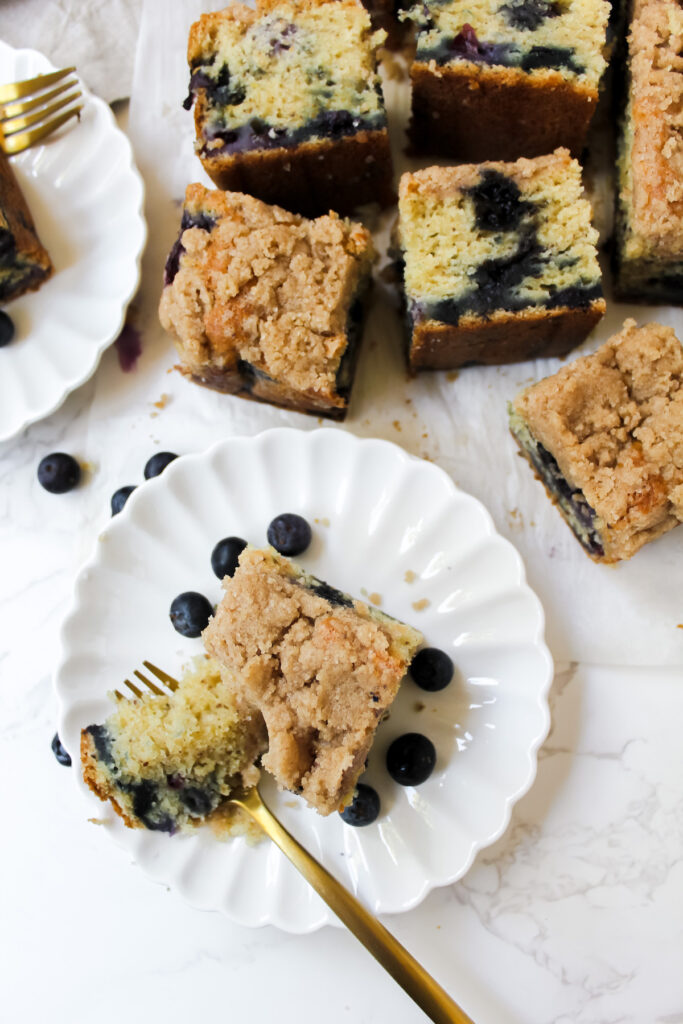 overview shot of slices of coffee cake and one on a plate with a bite on a fork