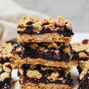healthy berry crumble bars stacked on top of each other