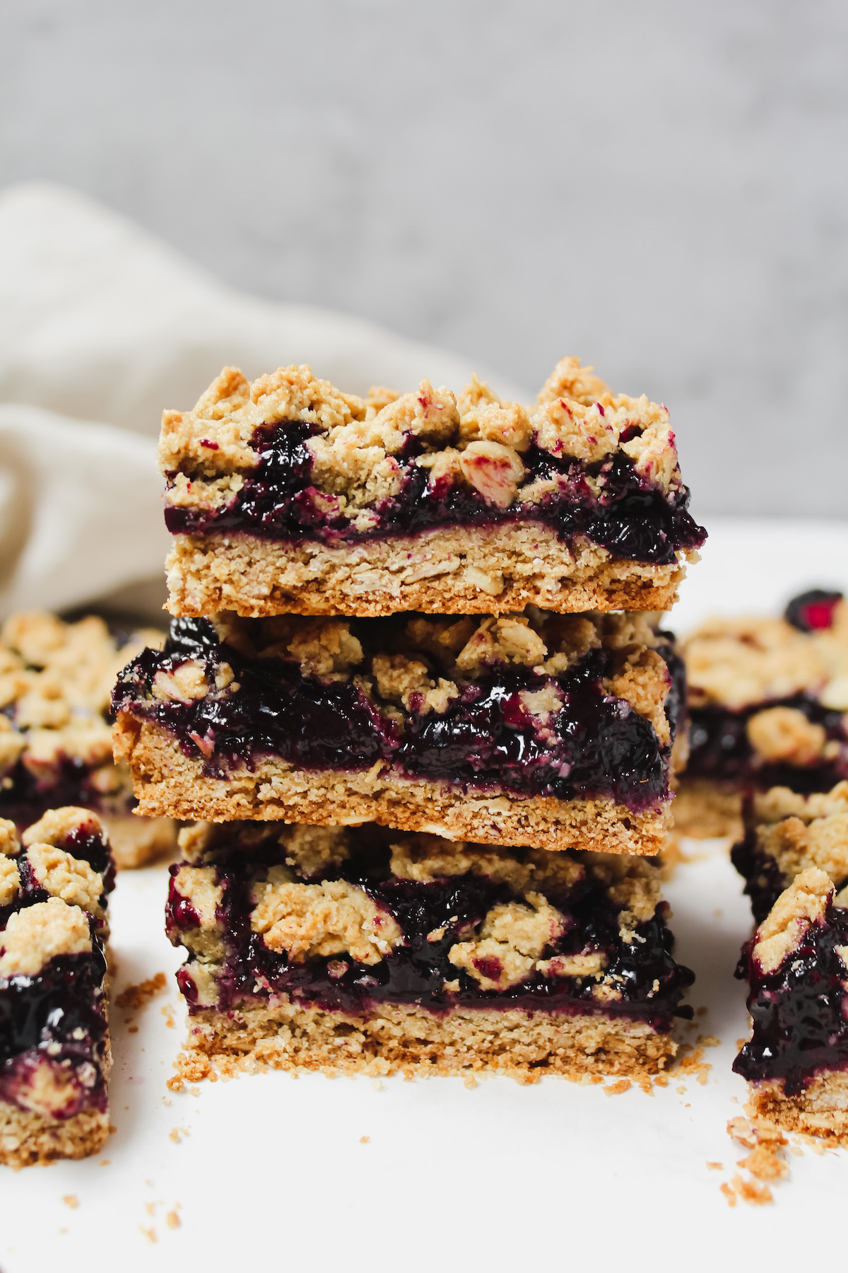 healthy berry crumble bars stacked on top of each other