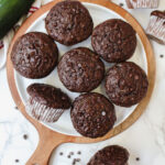 overview shot of healthy double chocolate zucchini muffins on a plate and some on the side