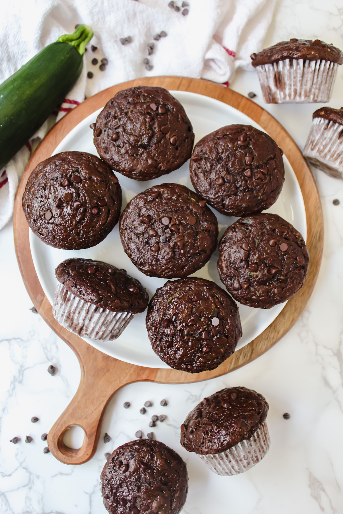 overview shot of healthy double chocolate zucchini muffins on a plate and some on the side