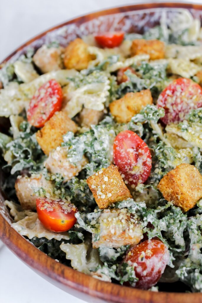 angled shot of pasta salad in a wooden bowl