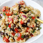 close up of quinoa salad in a bowl with spoon