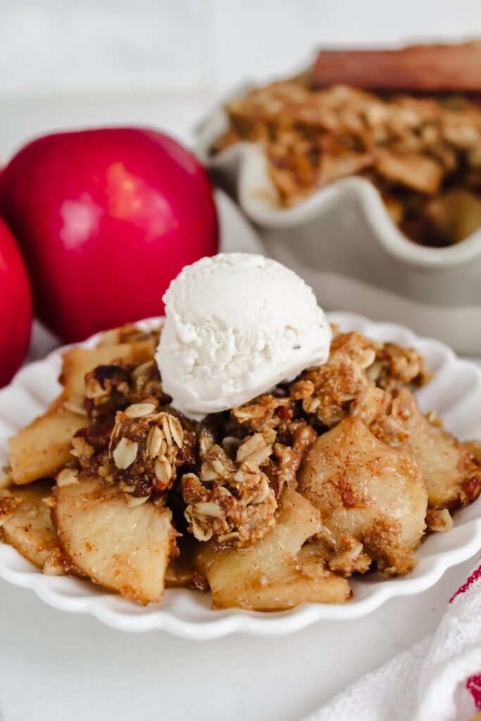 apple crisp with ice cream on a white plate