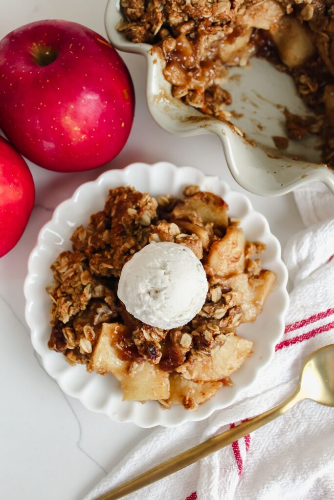 overview shot of apple crisp on a plate with ice cream