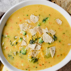 bowl of soup with crackers on top and off to the side