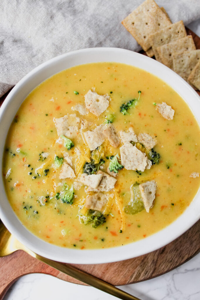 bowl of soup with crackers on top and off to the side