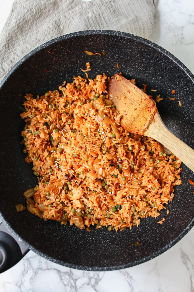 kimchi fried rice in a wok with a wooden spatula