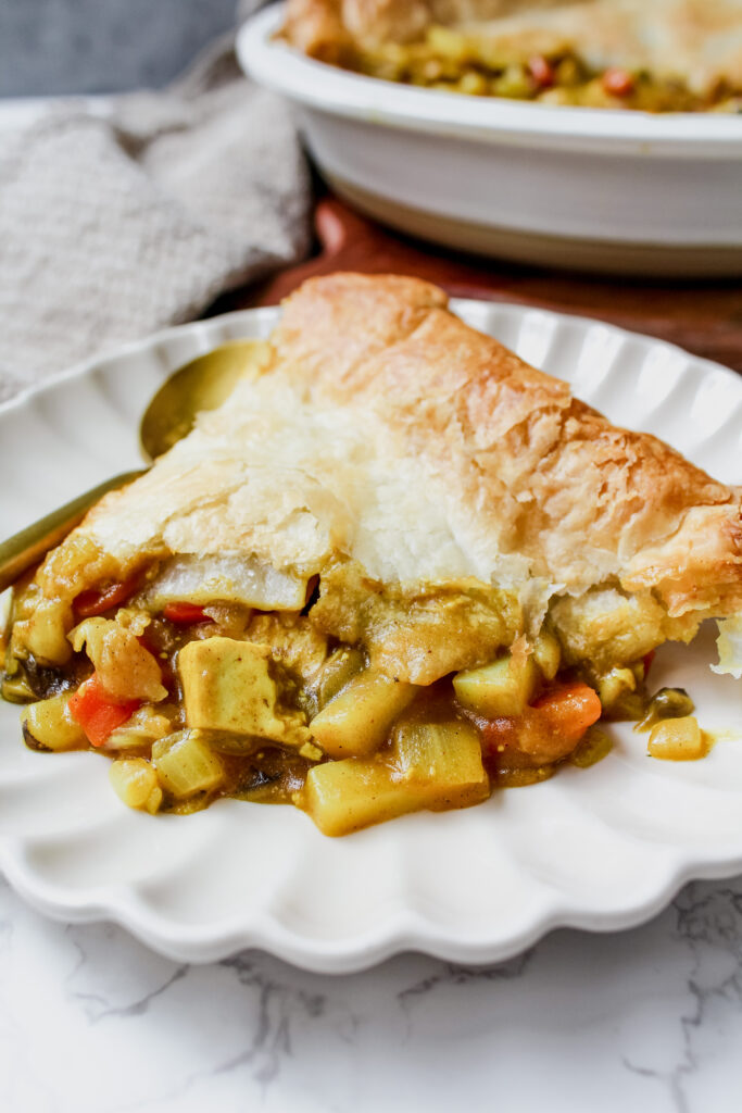 angled shot of a slice of vegan Japanese curry pot pie on a plate 