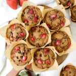 overview shot of strawberry chocolate chip muffins on a wooden board