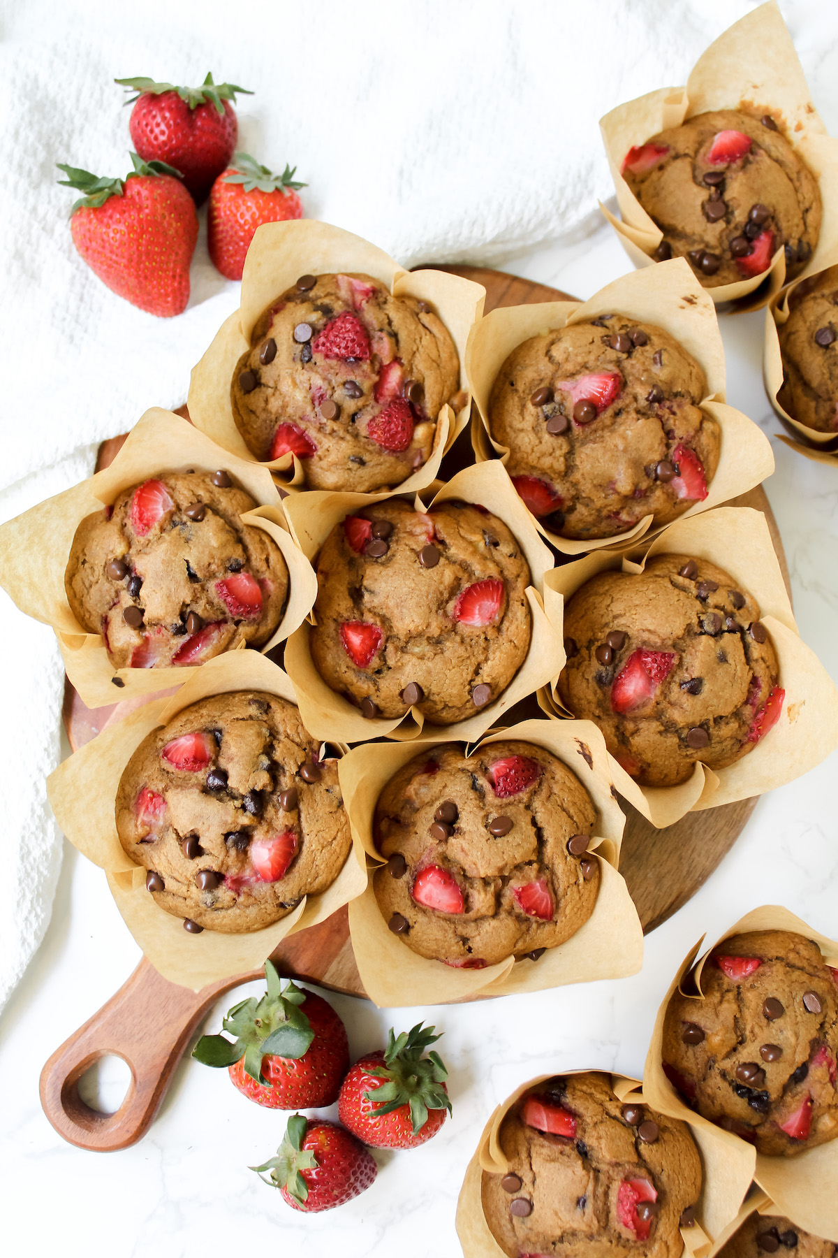 overview shot of strawberry chocolate chip muffins on a wooden board
