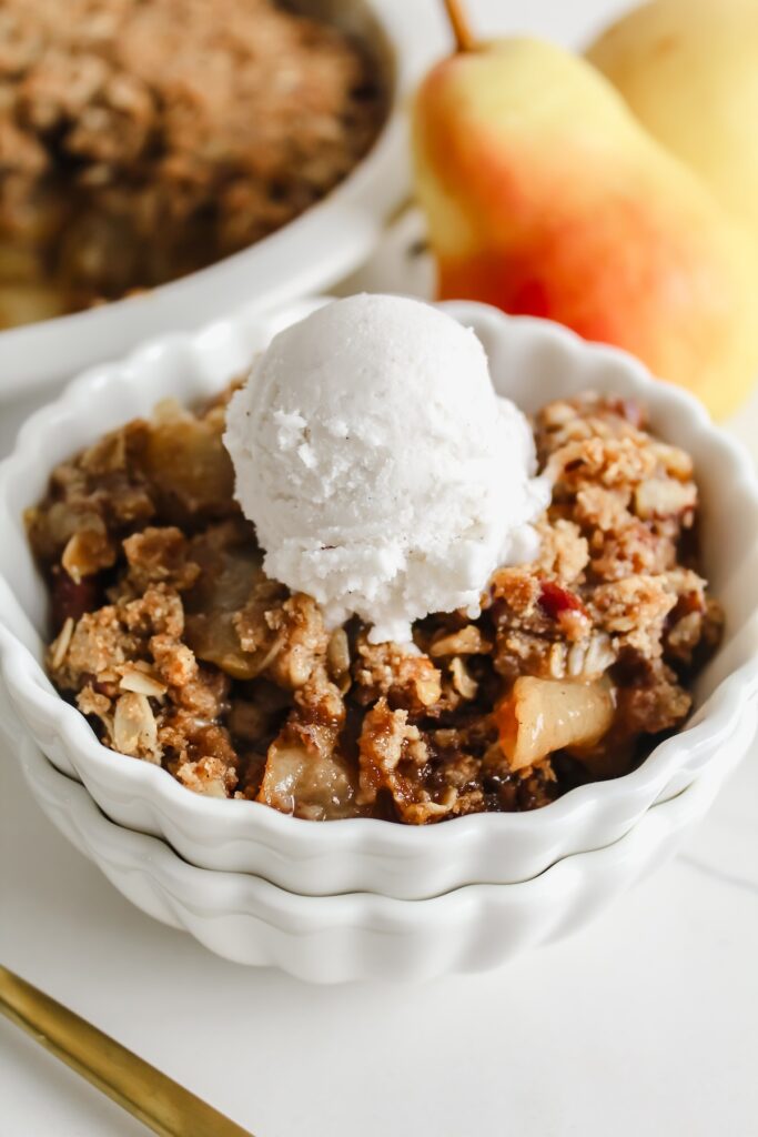 pear crisp in a bowl with ice cream on top