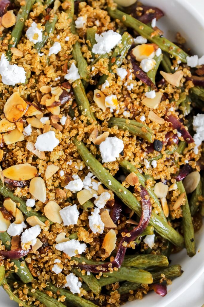 close up shot of roasted green beans with chili oil crispy quinoa