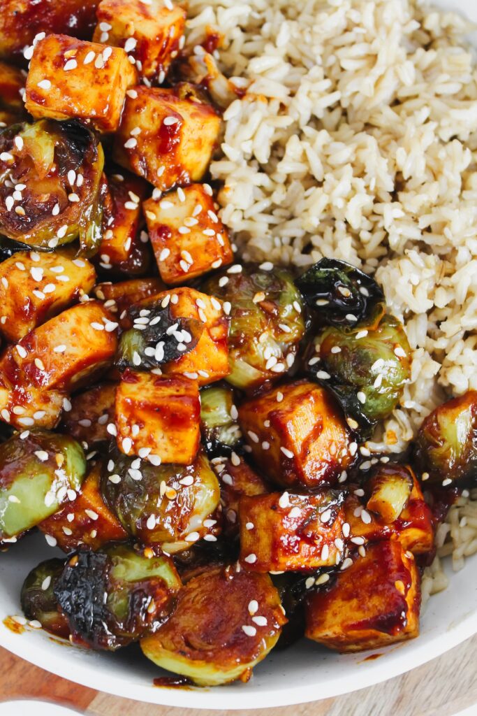 close up shot of brussels sprouts and tofu and rice