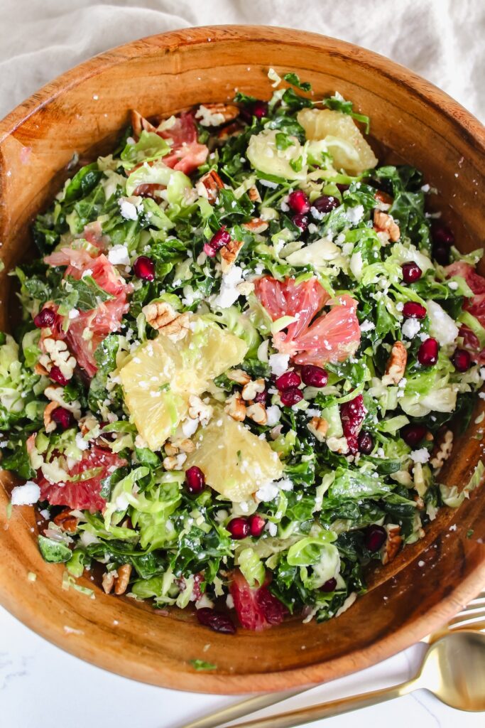 wooden bowl with shaved brussels sprouts and kale citrus salad