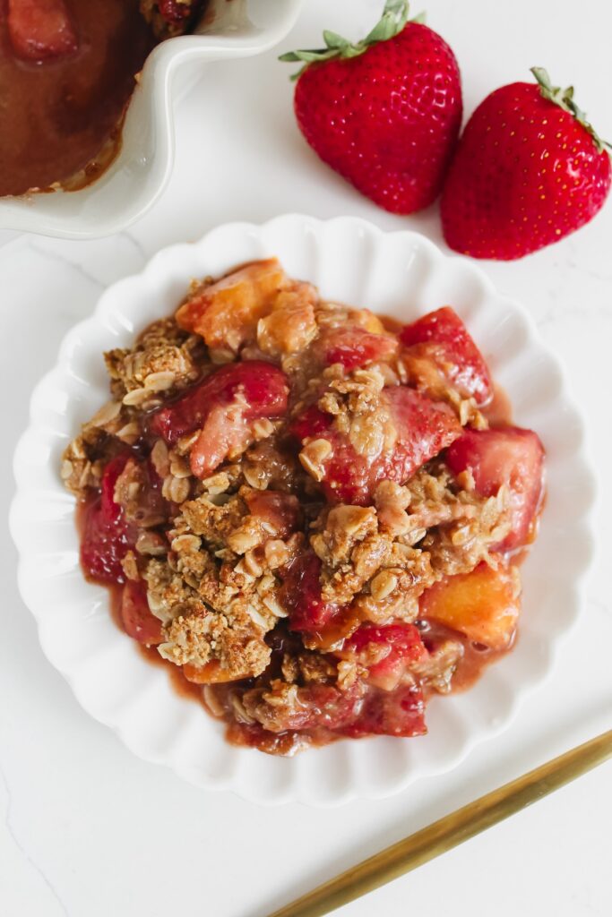 overview shot of strawberry peach crisp on a white plate