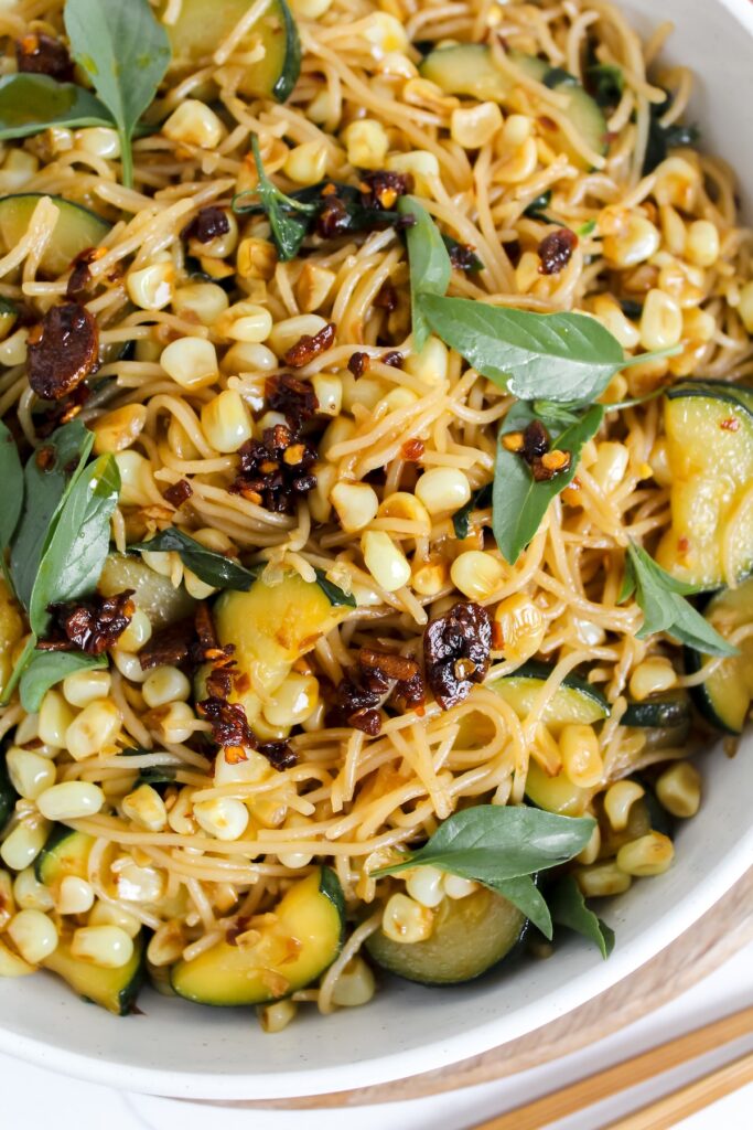 close up shot of plate of thai basil chili crisp corn and zucchini noodles