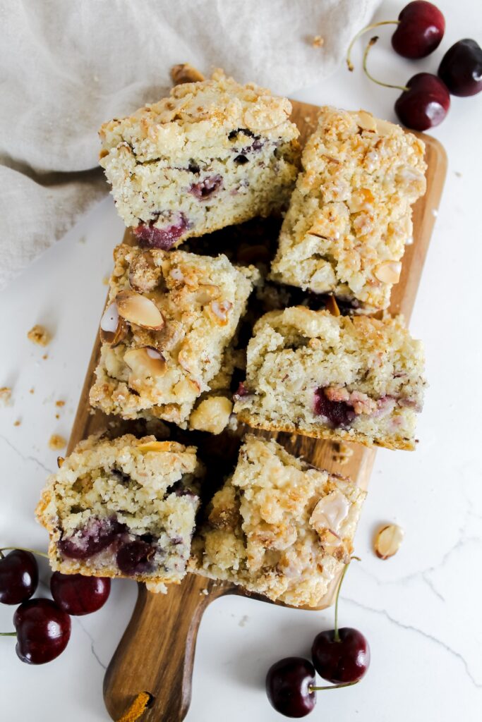 overview shot of slices of vegan cherry coffee cake on a wooden board