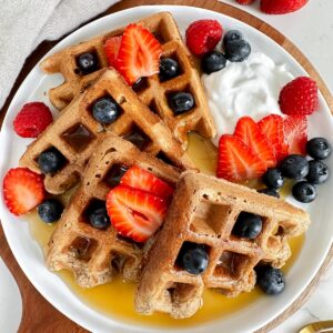 overview shot of a plate of vegan protein waffles with maple syrup on top