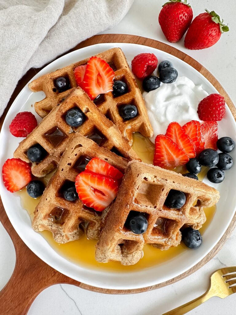 overview shot of a plate of vegan protein waffles with maple syrup on top